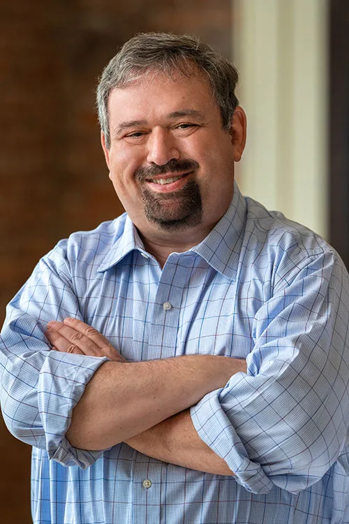 Edward H. Talmadge, arms crossed, smiling, in a blue checked shirt